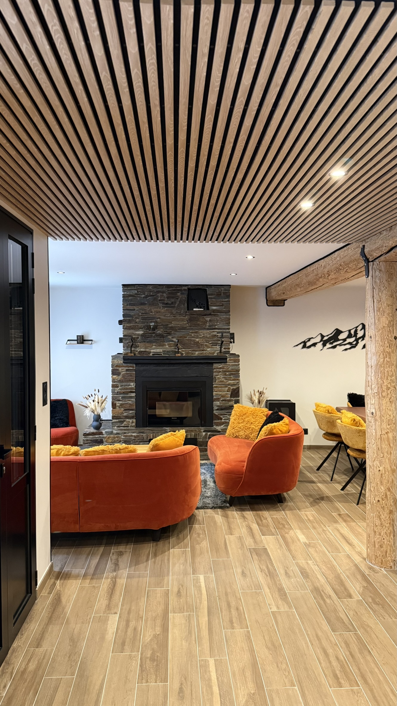 Salon spacieux avec poêle à pellet et canapés orange de la maison de vacances 4 étoiles à Bagnères-de-Luchon