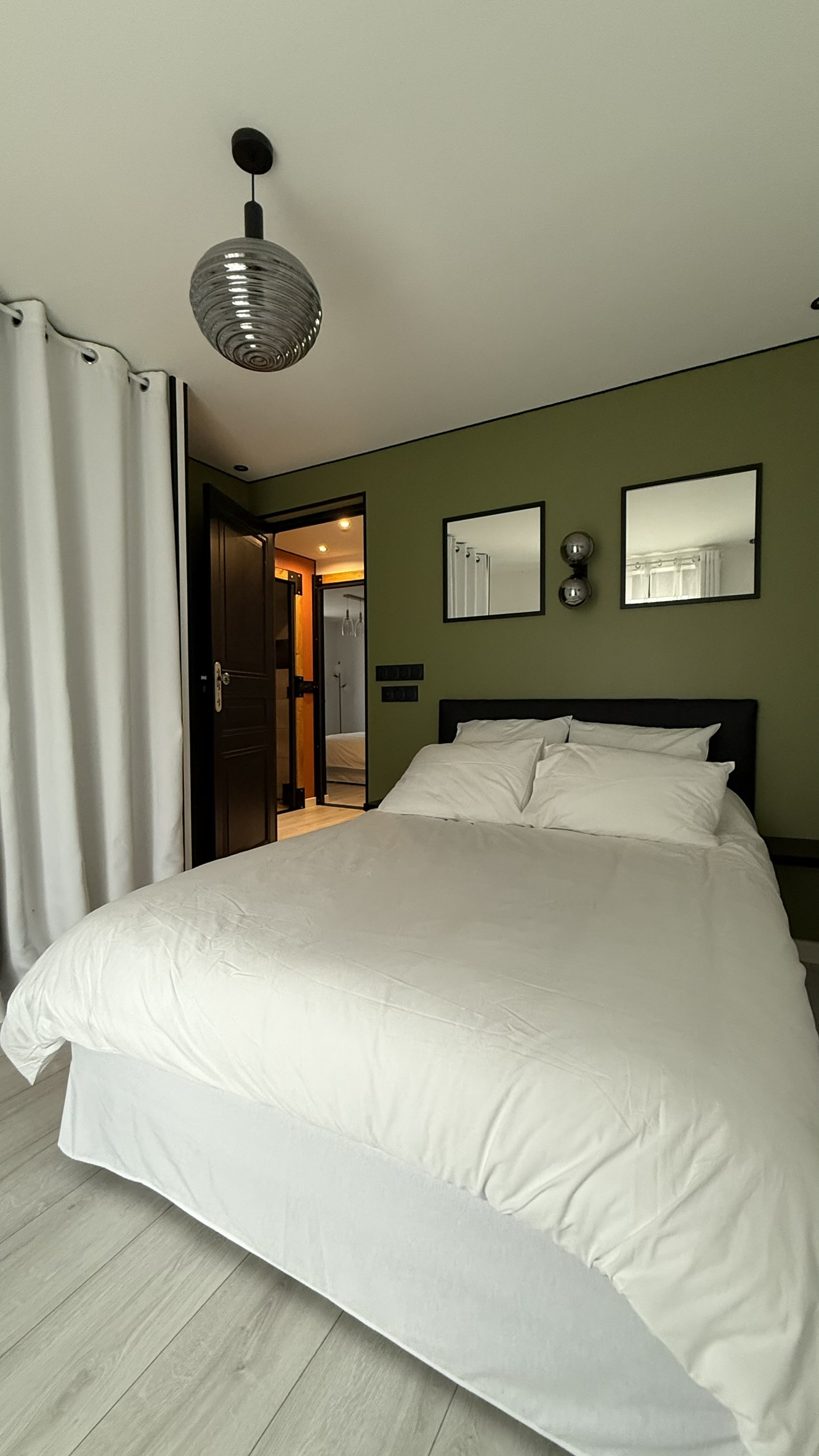 Chambre spacieuse avec lit double et mur vert dans la maison 4 étoiles Pyren'air Locations à Luchon