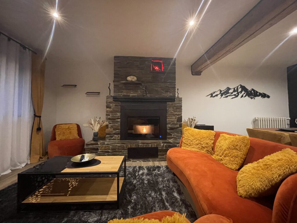 Salon chaleureux de la maison de vacances 4 étoiles à Bagnères-de-Luchon avec poêle à pellet et décoration montagne Pyrénées